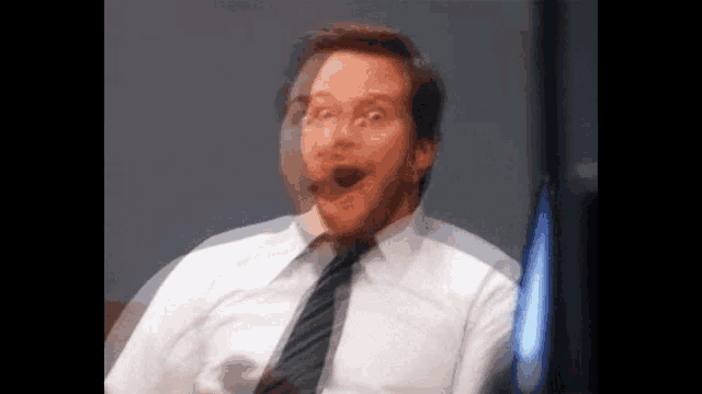 a man in a suit and tie is making a surprised face