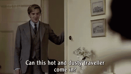 a man in a suit and tie is standing in a room talking to another man .