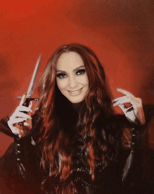 a woman with long red hair is holding a knife in her hands