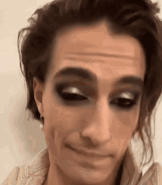 a close up of a person 's face with makeup on it making a funny face .