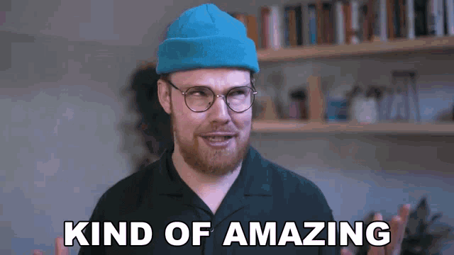 a man with a beard wearing glasses and a blue hat is saying kind of amazing