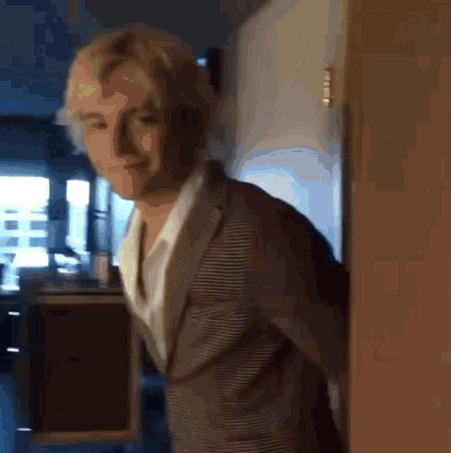 a man in a suit is standing in a doorway looking at the camera .