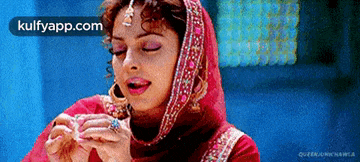 a woman in a red dress is holding something in her hands with the words kulfyapp.com on the bottom