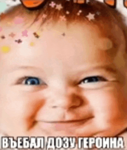 a close up of a baby 's face with sprinkles on his head .