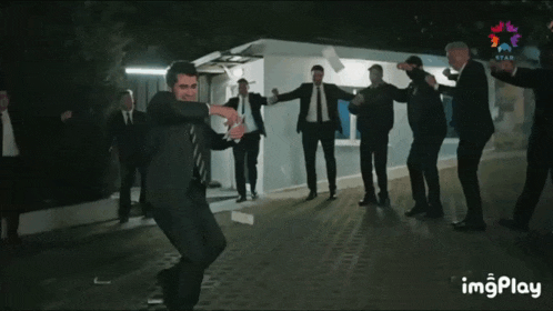a group of men in suits and ties are dancing in front of a star tv sign