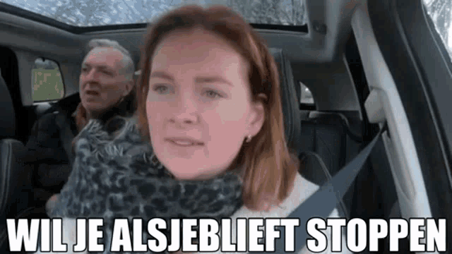 a man and a woman are sitting in the back seat of a car with the words wil je alsjeblieft stoppen above them .