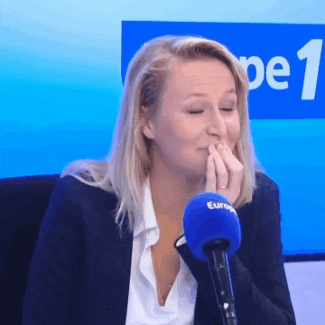 a woman covering her mouth in front of a microphone that says europe 1 on it