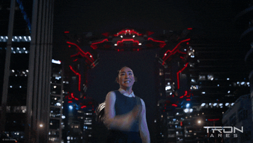 a poster for tron ares shows a woman standing in front of a robot