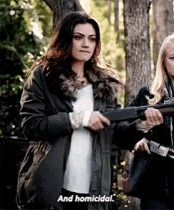 a woman is holding a gun and saying `` and homicidal '' while standing next to another woman .