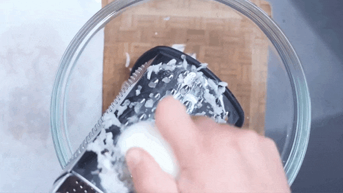 a person is grating something in a bowl with a grater .