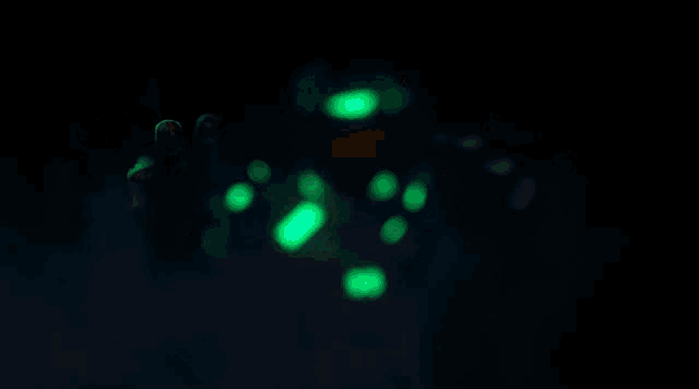 a robotic pumpkin with glowing eyes is holding a glowing object in its mouth