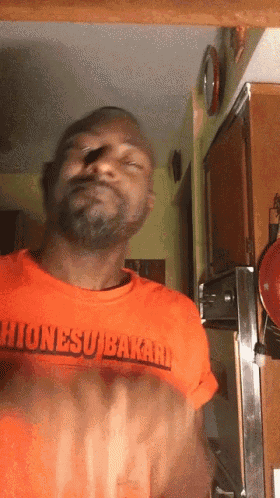 a man wearing an orange shirt that says hionesu bakari on it