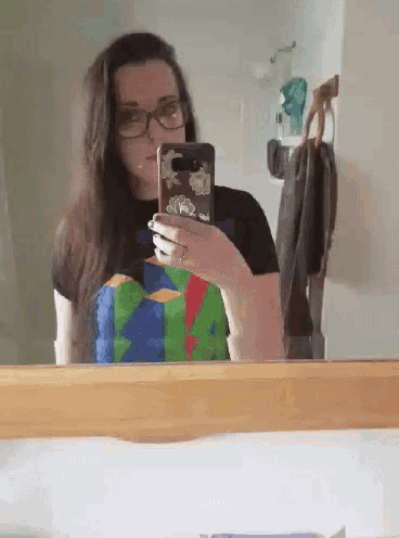 a woman is taking a picture of herself in a bathroom mirror