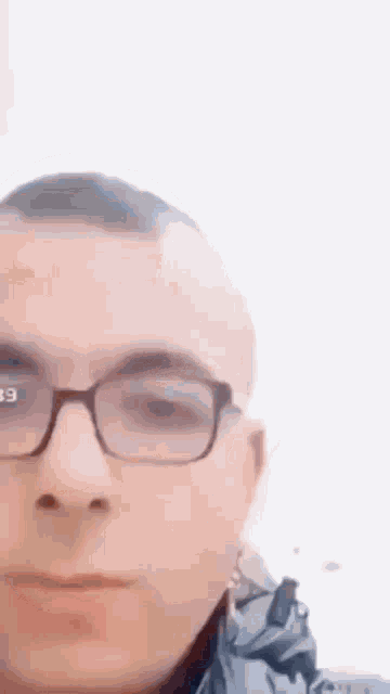 a man wearing glasses is looking at the camera with a white background .