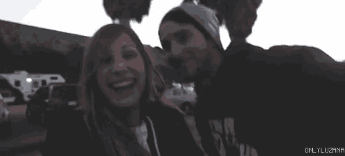 a man and a woman are laughing and smiling at the camera .