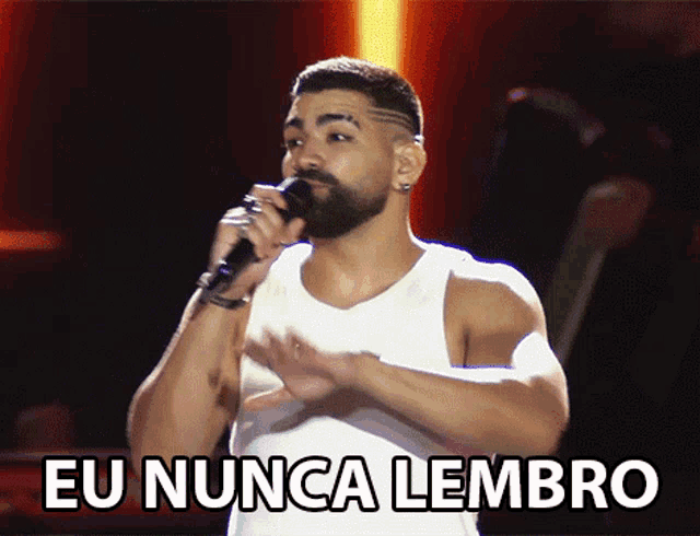 a man singing into a microphone with the words " eu nunca lembro " below him