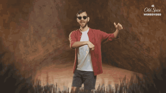 a man wearing sunglasses is dancing in front of an ad for old spice