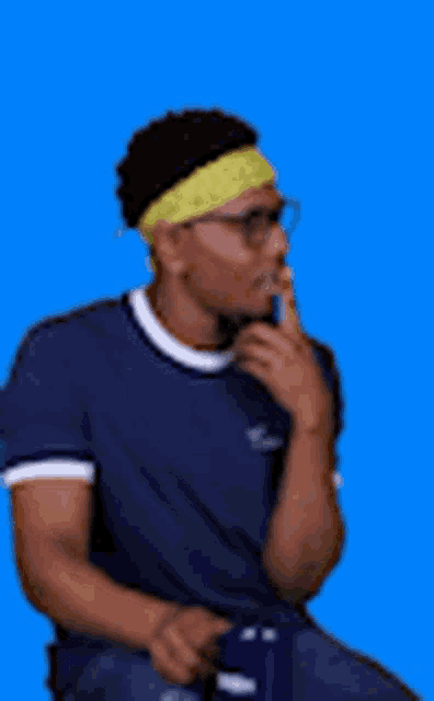 a man wearing glasses and a headband is sitting on a chair .
