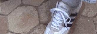 a person is wearing a pair of white and black adidas shoes