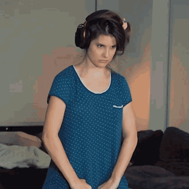 a woman wearing headphones and a blue polka dot dress