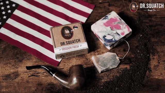 a box of dr. squatch soap sits on a wooden table next to an american flag