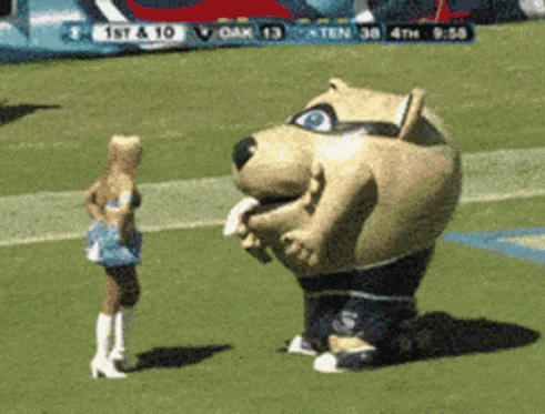 a cheerleader stands next to a mascot on a field with a scoreboard behind them that says 1st & 10