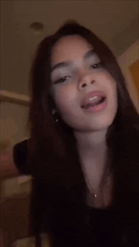 a close up of a woman 's face with her mouth open and a blurry background .