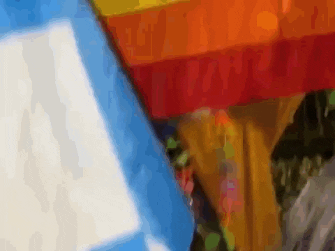 a person is holding a rainbow colored umbrella in front of a blue sky .
