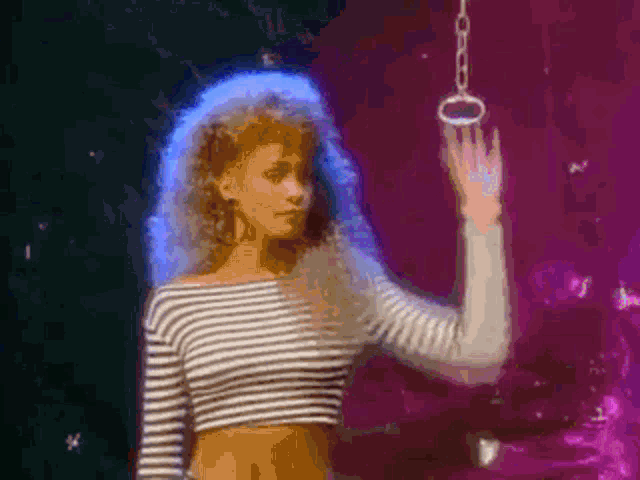 a woman in a striped shirt is standing in front of a chain .