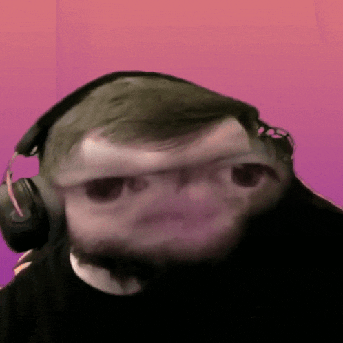 a blurry picture of a man wearing headphones with a pink background