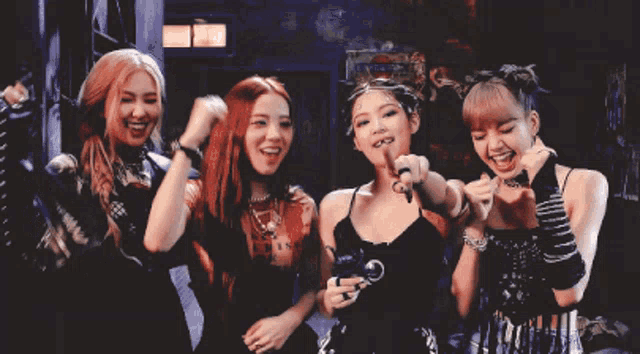 a group of women are posing for a picture and one of them is wearing a black dress