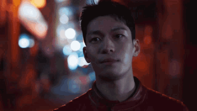 a close up of a man 's face with lights in the background