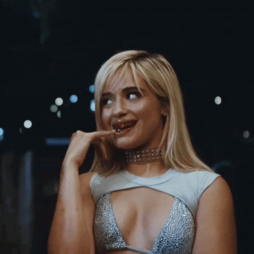a woman wearing a choker and a very plunging top is making a funny face