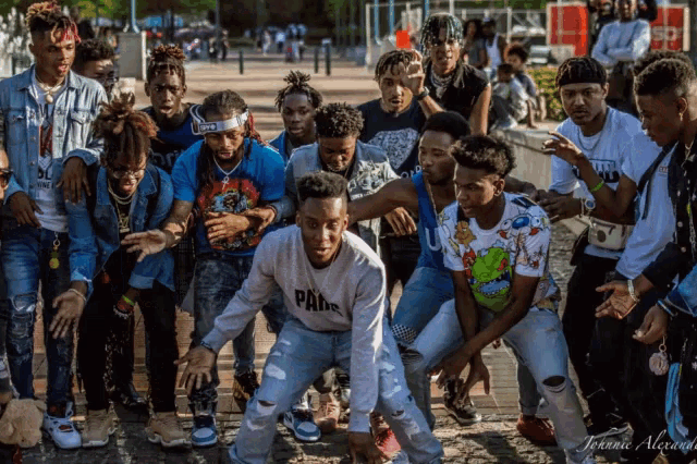 a group of young men are posing for a photo and one of them is wearing a pans sweatshirt
