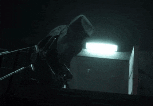 a person in a dark room with a light behind them