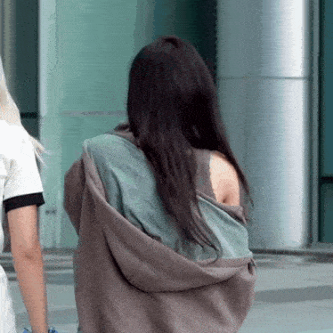 the back of a woman wearing a hoodie and a bra