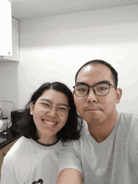 a man and a woman wearing glasses are posing for a photo