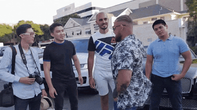 a man wearing a shirt that says ufc is talking to a group of men
