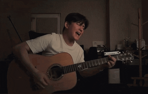 a man singing into a microphone while playing a guitar with a yamaha logo on it