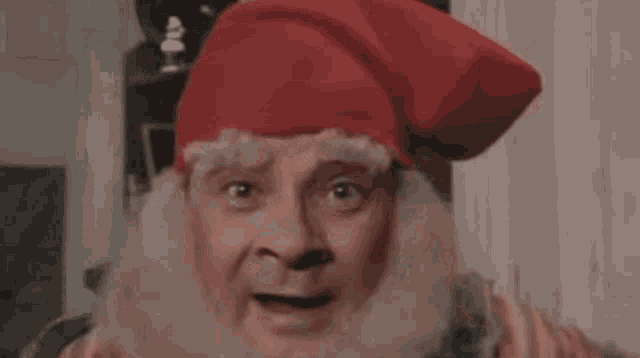 a close up of a man wearing a red hat and beard .