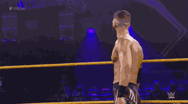 a man in a wrestling ring with # 205live written on the bottom