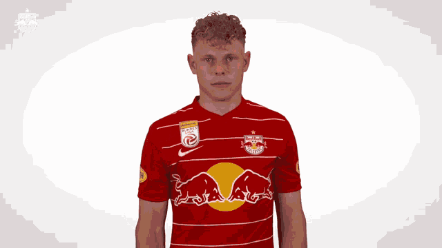 a man wearing a red and white striped red bull jersey