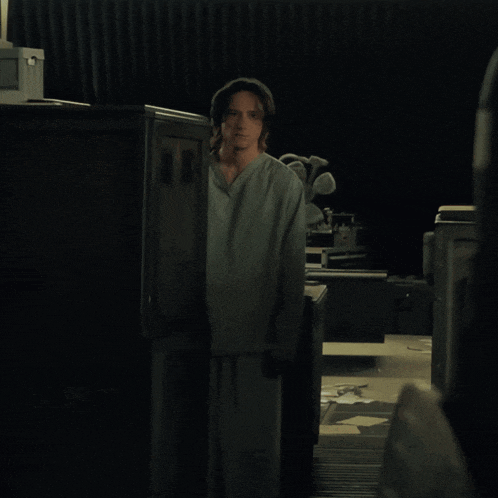 a man in a scrub is standing in front of a cabinet that says ' a ' on the front