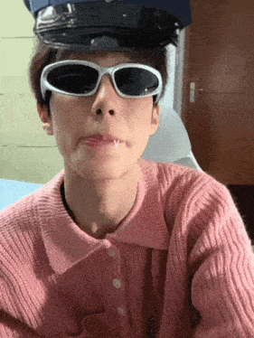 a man wearing sunglasses and a police hat is making a face