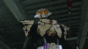 a person in a white and black costume with orange eyes stands in a dark room