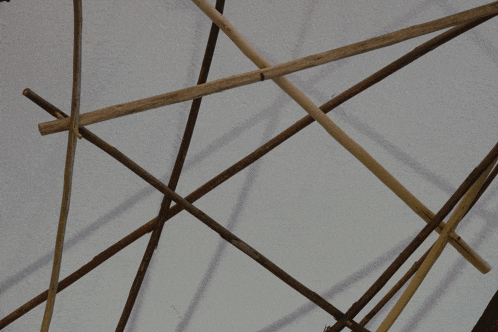a bunch of wooden sticks are stacked on top of each other