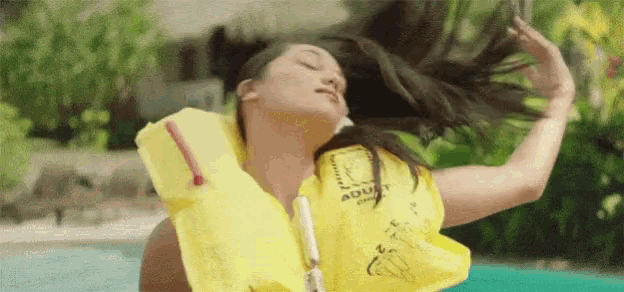 a woman is wearing a yellow life vest that says adult