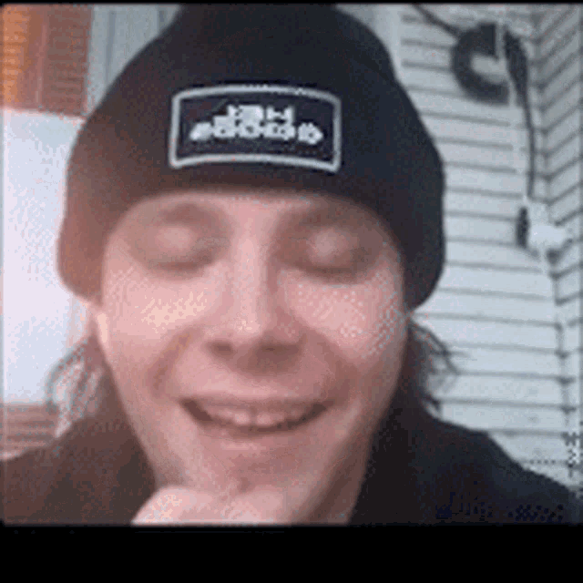 a man wearing a black beanie with a patch on it that says ' jdp ' on it