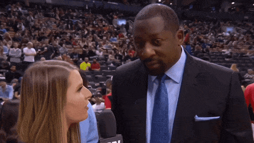 a man in a suit and tie is talking to a reporter