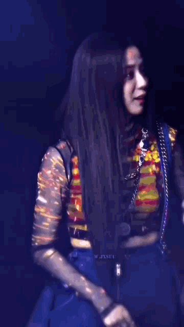a woman with long black hair is smiling and wearing a striped shirt and a necklace .